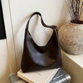 Bolso tote de cuero marrón retro con correa ancha sobre una maleta plateada vintage - Marrón