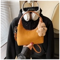 Detailansicht der braunen Hobo-Bag aus Wildleder mit flauschigem Hundeanhänger - Braun mit Anhänger