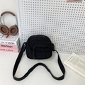 Minimalist black corduroy crossbody bag with adjustable strap and front pocket detail - Black