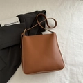 Bolso cubo minimalista de cuero marrón con correa ajustable y detalles metálicos dorados - Marrón