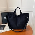 Bolso tote de pana negra de gran capacidad con correas en un ambiente acogedor - Negro