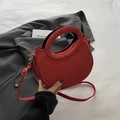 Borsa a mezzaluna rossa scintillante con trama lucida e manico rotondo su lenzuolo - Rosso
