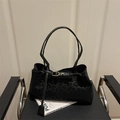 Grande borsa tote nera con stampa leopardata e fibbia dorata su una poltrona di stile - Nero
