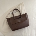 Bolso tote marrón oscuro con relieve de cocodrilo y asas sobre un elegante fondo crema - Marrón