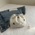 White quilted drawstring tote bag with black floral embroidery and thin shoulder straps - White