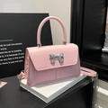 Elegante borsa a tracolla rosa con fiocco in metallo argento e trama glitterata su sfondo - Rosa