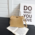 Sac Kelly doré avec texture crocodile sur livre ouvert, style rétro français élégant - Doré