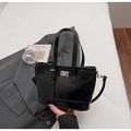Schwarze glänzende Eimer-Tasche mit Silberschnalle in einem minimalistischen Modeumfeld - Schwarz