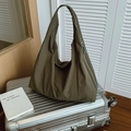 Olijfgroene nylon shopper met kreuktextuur geplaatst op een zilveren koffer - Groen