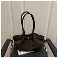 Detail of dark brown matte leather tote bag with elegant gold metal buckle on a chair - Coffee
