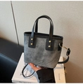 Detail van grijze denim tote tas met leren riemen en gouden klinknagels voor schouder of hand - Donkerbruin