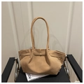Detail of camel suede tote bag with slim shoulder strap and decorative buckle on a chair - Khaki