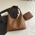 Grande borsa hobo marrone scuro in ecopelle con pochette coordinata su sfondo bianco - Marrone