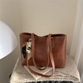 Grande borsa tote marrone scuro con trama vintage e sciarpa di seta su sfondo morbido - Cuoio