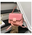 Nahaufnahme der rosa Taschenklappe mit glänzender Krokostruktur und stilvoller Schnalle - Rosa
