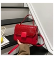 Detailansicht der roten Handtasche mit Krokodilprägung und goldenen Elementen - Rot