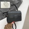Sac bandoulière chic en similicuir crocodile noir avec poignée sur fond gris élégant - Noir
