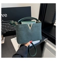 Détail du sac seau vert foncé montrant les coutures en daim et la boucle en V dorée - Vert