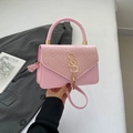 Pink patchwork crossbody bag with woven texture, golden S hardware and elegant tassel detail - Pink
