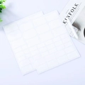 Waterproof white PVC labels with vintage wavy borders on a minimalist desk setup - White