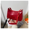 Detail van rode handtas met slangenpatroon, gouden beslag en een acryl ketting - Rood