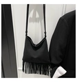 Detail of black leather crossbody bag with dense tassels and minimalist shoulder strap - Black