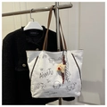 Dettaglio della borsa tote in tela bianca con illustrazioni e manici in pelle - Bianco (Con Ciondolo)