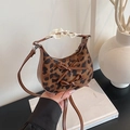 Mini-Handtasche mit Leopardenmuster Lederbögen und Spitzengriff auf minimalistischem Tisch - Brauner Leopardenprint