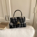 Detailed view of British style plaid handbag with leather straps and golden metal buckle - Black