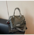 Detalle de bolso de nylon verde oliva con asas de cuerda gris y placa metálica - Gris