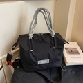 Bolso tipo cubo de nailon negro con asas de cuerda trenzada y correa roja lateral - Negro