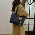 Bolso tote negro de cuero granulado con colgante de oso y abrigo color mostaza - Negro