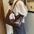 Detail of dark brown glossy tote bag with crinkled texture and grey bunny charm - Coffee with Pendant