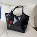 Detalle del bolso tote de charol negro con colgante de estrella y cuentas modernas - Negro