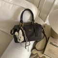Detail of dark brown leather Boston bag with gold hardware and white plush rabbit charm - Coffee with Pendant