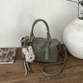 Detail of grey-green Boston bag with gold hardware, logo, and plush puppy charm - With Pendant / Green