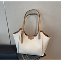 Dettaglio di una borsa tote in ecopelle color crema con trama a grana e manici marroni - Bianco Sporco