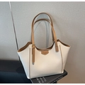Primer plano detallado de un bolso tote de cuero crema con asas marrones y textura granulada - Blanco Roto