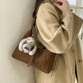 Brown suede shoulder bag with plush rabbit charm worn with a beige wool coat - Brown with Pendant