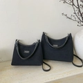 Minimalist black hobo bags in two sizes on a stone surface with decorative branches - Large / Black