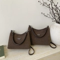 Macro detail of dark brown suede dumpling bags in two sizes with branding labels - Large / Brown