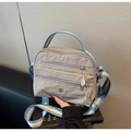 Dettaglio borsa a tracolla in nylon grigio con tasche a zip e tracolla larga a righe - Grigio