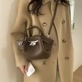 Sac seau plissé marron avec boucle argentée et mini pochette sur manteau beige - Marron