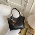 Detalle del bolso bajo el brazo vintage gris con charm de monstruo de pelo en un sofá - Con Colgante / Negro