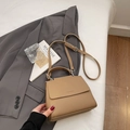 Khaki pebbled leather handbag with adjustable strap on a lifestyle bed background - Khaki (No Pendant)