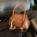 Brown vintage pillow bag in glossy leather with circular handles and beaded charm - Brown