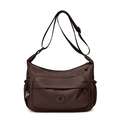 Detailed view of dark brown nylon crossbody bag with front zipper and side elastic pockets - Deep purple