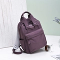 Details des lila Nylonrucksacks mit atmungsaktiven Netzgurten und Reißverschlusstaschen - Lila