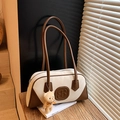 Retro cream shoulder bag with brown trim and bear charm on a wooden shelf - With Charm / Off White