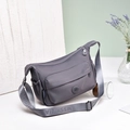 Dettaglio della borsa a tracolla in nylon multitasche con ampia tracolla regolabile e logo - Viola Chiaro